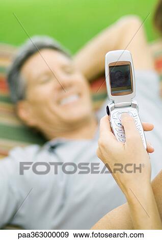 Hand taking picture of man in hammock with photo phone View Large Photo Image Stock Photo - Hand taking picture of man in hammock with photo phone. Fotosearch
