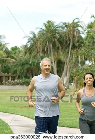 Mature couple running on walkway View Large Photo Image Stock Photograph - Mature couple running on walkway. Fotosearch