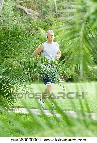 Mature man jogging on walkway View Large Photo Image Stock Image - Mature man jogging on walkway. Fotosearch