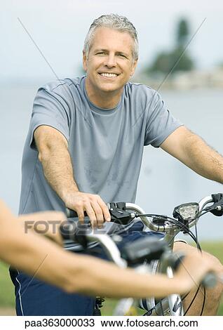 Mature man on bike, smiling View Large Photo Image Stock Image - Mature man on bike, smiling. Fotosearch