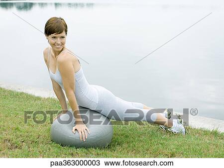 Stock Image - Woman exercising with pilates ball. Fotosearch