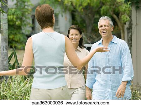 Woman greeting mature couple View Large Photo Image Stock Photograph - Woman greeting mature couple. Fotosearch