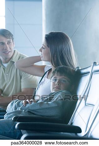 Family sitting in airport lounge, boy looking at camera View Large Photo Image Stock Photo - Family sitting in airport lounge, boy looking at camera. Fotosearch