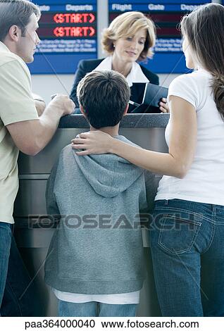 Family standing at airline check-in counter View Large Photo Image Stock Image - Family standing at airline check-in counter. Fotosearch