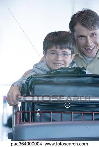 Man and son pushing luggage cart View Large Photo Image Picture - Man and son pushing luggage cart. Fotosearch