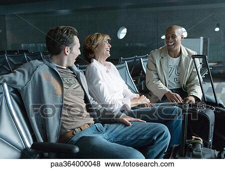 Travelers chatting in airport lounge View Large Photo Image Stock Photo - Travelers chatting in airport lounge. Fotosearch