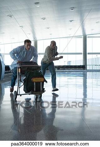 Stock Photo - Travelers hurrying though airport. Fotosearch