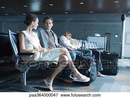 Travelers sitting in airport lounge View Large Photo Image Stock Photo - Travelers sitting in airport lounge. Fotosearch