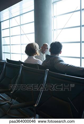Travelers sitting in airport lounge View Large Photo Image Stock Photograph - Travelers sitting in airport lounge. Fotosearch