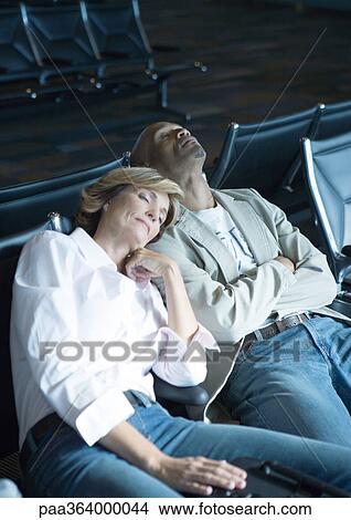 Travelers sleeping in airport lounge View Large Photo Image Picture - Travelers sleeping in airport lounge. Fotosearch