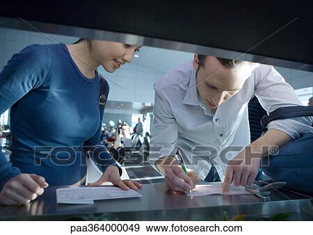 Stock Photo - Two people filling in forms. Fotosearch