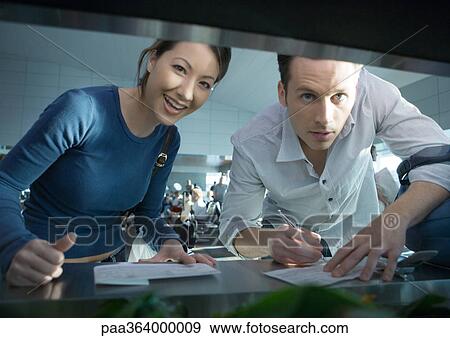 Woman and man filling out forms, looking at camera View Large Photo Image Stock Photo - Woman and man filling out forms, looking at camera. Fotosearch