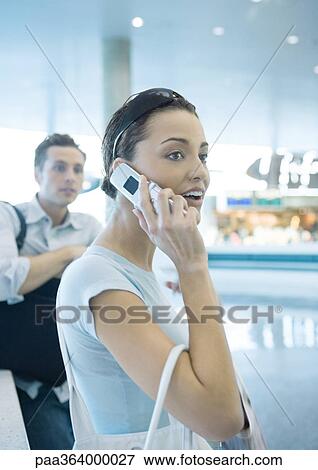 Woman using cell phone in airport View Large Photo Image Stock Photo - Woman using cell phone in airport. Fotosearch