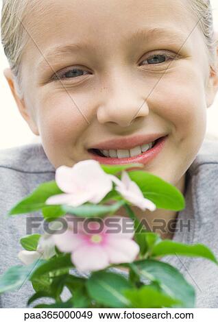Girl smiling with Vinca plant View Large Photo Image Stock Photo - Girl smiling with Vinca plant. Fotosearch
