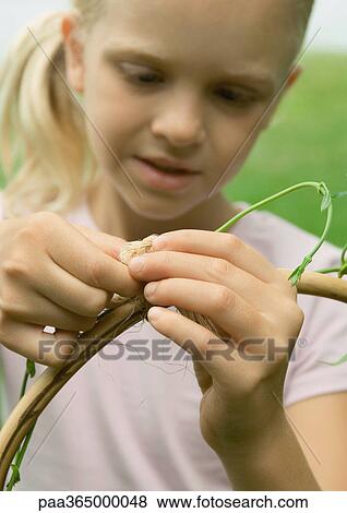 Girl wrapping vine around wooden pole View Large Photo Image Stock Photo - Girl wrapping vine around wooden pole. Fotosearch