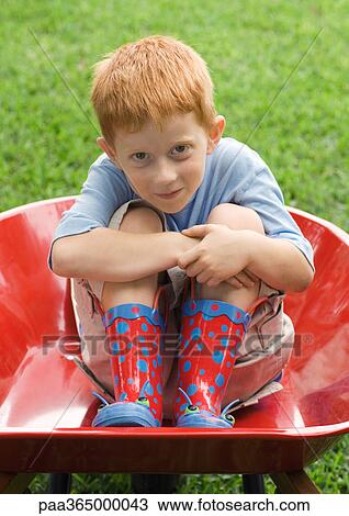 Little boy sitting in wheelbarrow View Large Photo Image Stock Image - Little boy sitting in wheelbarrow. Fotosearch