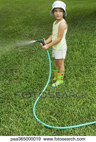 Little girl standing with garden hose View Large Photo Image Stock Photo - Little girl standing with garden hose. Fotosearch