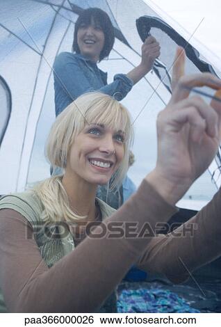 Two women putting up tent View Large Photo Image Stock Photograph - Two women putting up tent. Fotosearch