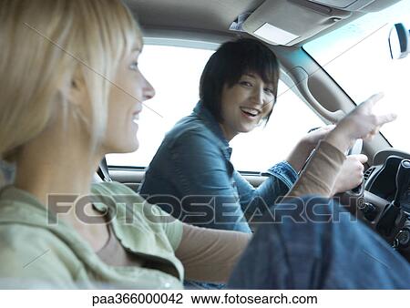 Stock Image - Two young adult female friends in car together. Fotosearch