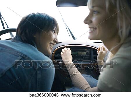 Stock Image - Two young adult female friends in car together. Fotosearch