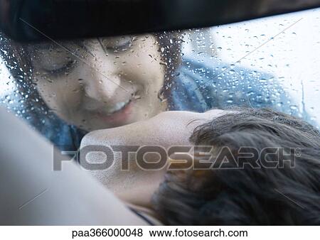 Woman about to kiss man through windshield View Large Photo Image Stock Photo - Woman about to kiss man through windshield. Fotosearch