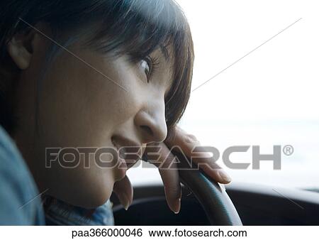 Woman leaning head against steering wheel View Large Photo Image Stock Photograph - Woman leaning head against steering wheel. Fotosearch