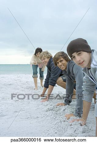 Young adult friends about to race on beach View Large Photo Image Stock Photograph - Young adult friends about to race on beach. Fotosearch