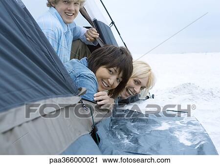 Young adult friends looking out of tent on beach View Large Photo Image Stock Image - Young adult friends looking out of tent on beach. Fotosearch