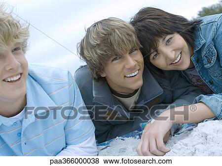 Young adult friends on beach, smiling View Large Photo Image Stock Photo - Young adult friends on beach, smiling . Fotosearch