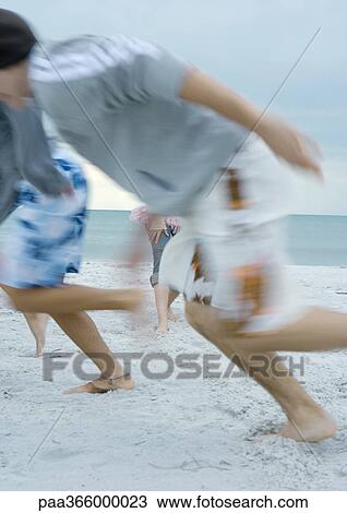 Young men running on beach View Large Photo Image Stock Image - Young men running on beach. Fotosearch
