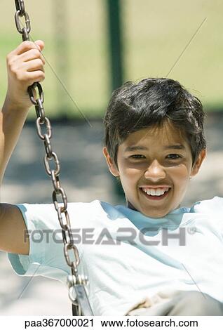 Stock Image - Preteen boy on swing. Fotosearch