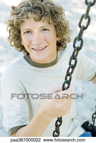 Stock Image - Preteen boy on swing. Fotosearch