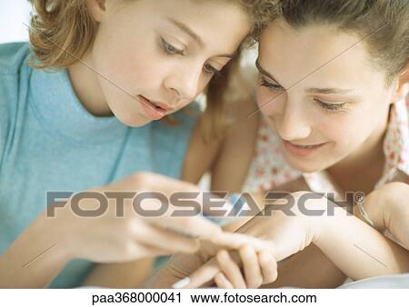 Preteen girl filing friend's nails View Large Photo Image Stock Image - Preteen girl filing friend's nails. Fotosearch