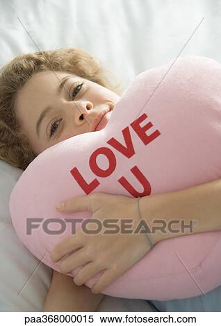 Preteen girl holding heart pillow View Large Photo Image Stock Photography - Preteen girl holding heart pillow. Fotosearch
