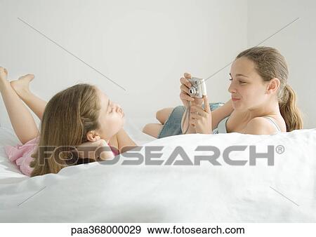 Preteen girl taking photo of friend View Large Photo Image Stock Photo - Preteen girl taking photo of friend. Fotosearch