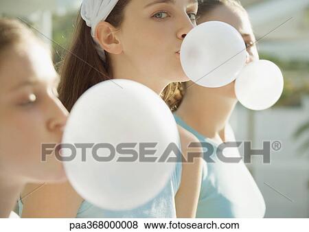 Stock Photo - Preteen girls blowing bubbles with chewing gum. Fotosearch
