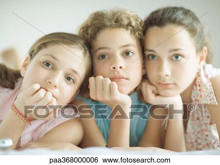 Preteen girls leaning on elbows, looking out of frame View Large Photo Image Stock Photograph - Preteen girls leaning on elbows, looking out of frame. Fotosearch