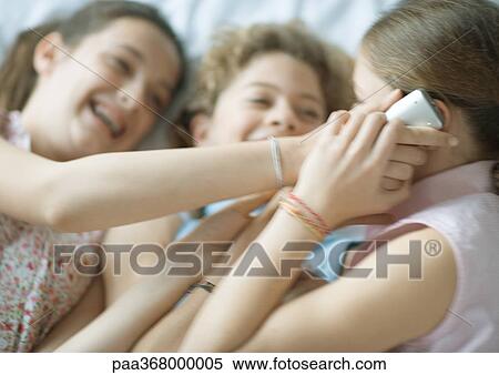 Preteen girls using cell phone, giggling View Large Photo Image Stock Photography - Preteen girls using cell phone, giggling. Fotosearch