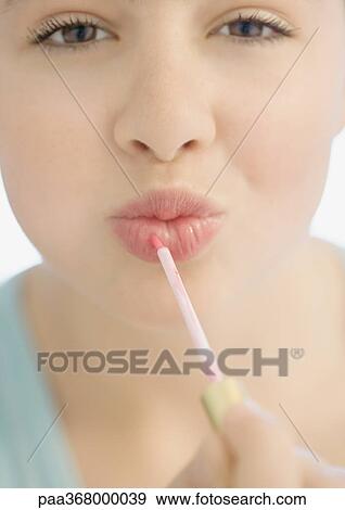 Teenage girl applying lipgloss View Large Photo Image Stock Photo - Teenage girl applying lipgloss. Fotosearch