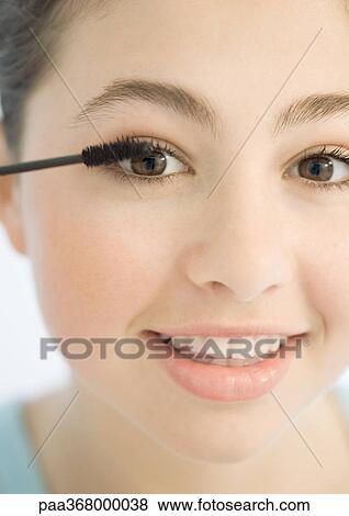 Teenage girl applying mascara View Large Photo Image Stock Photo - Teenage girl applying mascara. Fotosearch