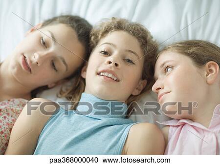 Teenage girls lying down together View Large Photo Image Stock Image - Teenage girls lying down together. Fotosearch