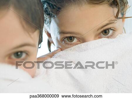 Two girls looking over edge of towel View Large Photo Image Stock Photo - Two girls looking over edge of towel. Fotosearch