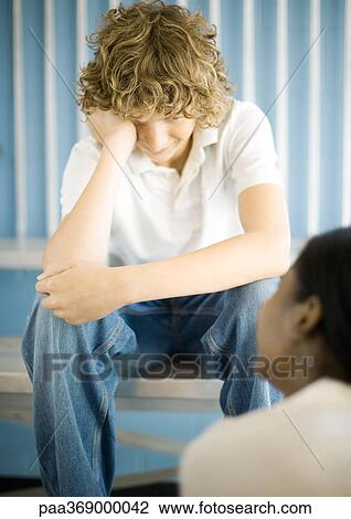 Teen boy facing teen girl, holding head View Large Photo Image Stock Image - Teen boy facing teen girl, holding head. Fotosearch