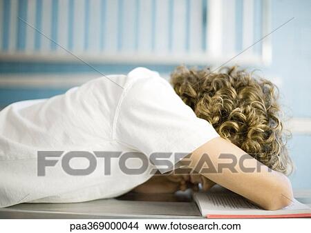 Teen boy with head down on school book View Large Photo Image Picture - Teen boy with head down on school book. Fotosearch