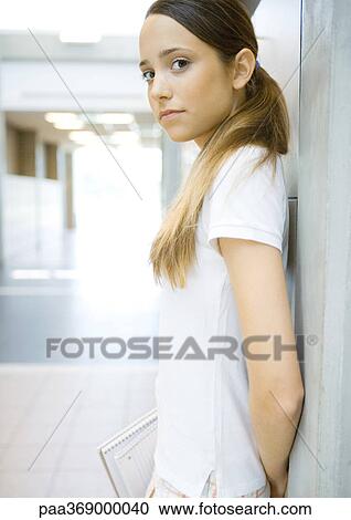Teen girl leaning against wall, looking at camera View Large Photo Image Stock Image - Teen girl leaning against wall, looking at camera. Fotosearch