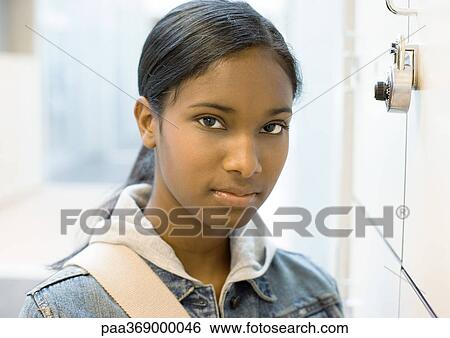 Teen girl standing next to locker View Large Photo Image Stock Photograph - Teen girl standing next to locker. Fotosearch
