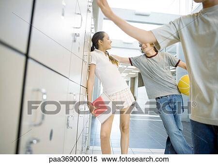 Teenage boy and girl leaning against lockers, talking View Large Photo Image Stock Photography - Teenage boy and girl leaning against lockers, talking. Fotosearch