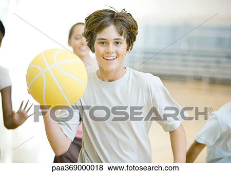 Teenage boy running with basketball in school gym, followed by classmates View Large Photo Image Stock Photo - Teenage boy running with basketball in school gym, followed by classmates. Fotosearch