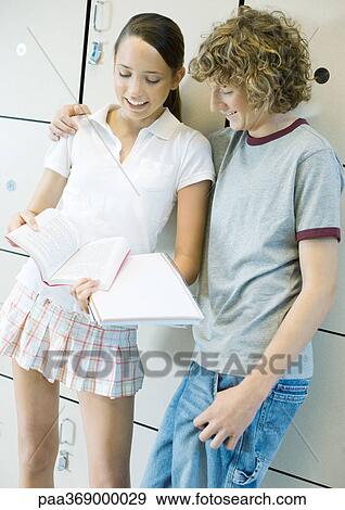Teenage couple leaning against lockers, talking about school work View Large Photo Image Stock Photo - Teenage couple leaning against lockers, talking about school work. Fotosearch