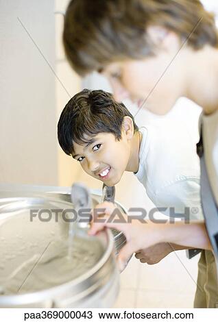 Two teen boys at water fountain View Large Photo Image Stock Image - Two teen boys at water fountain. Fotosearch